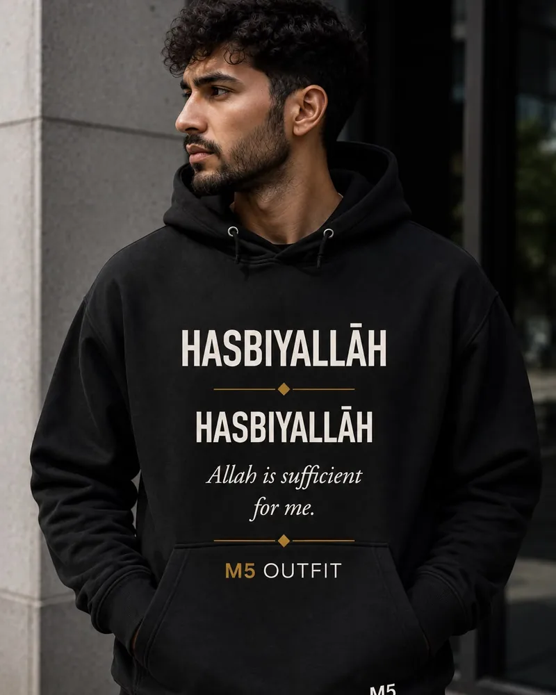 Model wearing a black M5 Outfit hoodie printed with the Arabic and English word Hasbiyallah