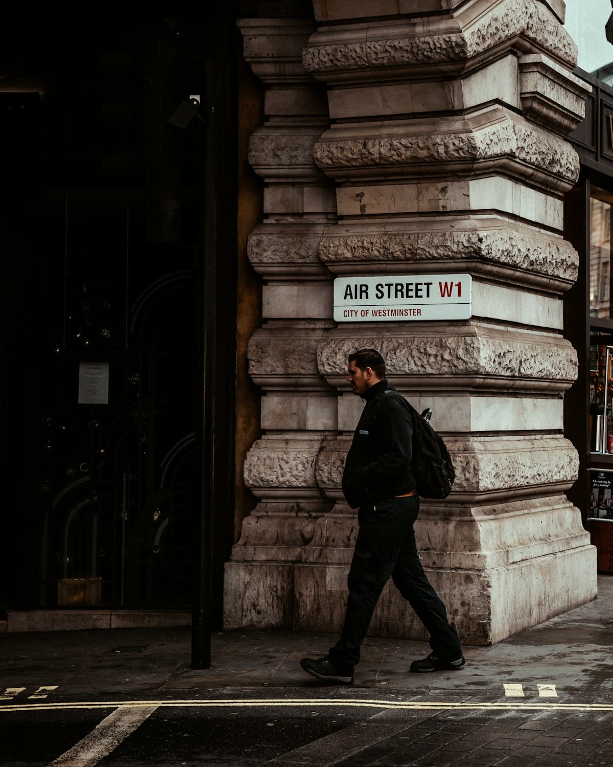 Model in an all-black M5 Outfit fit walking a London street