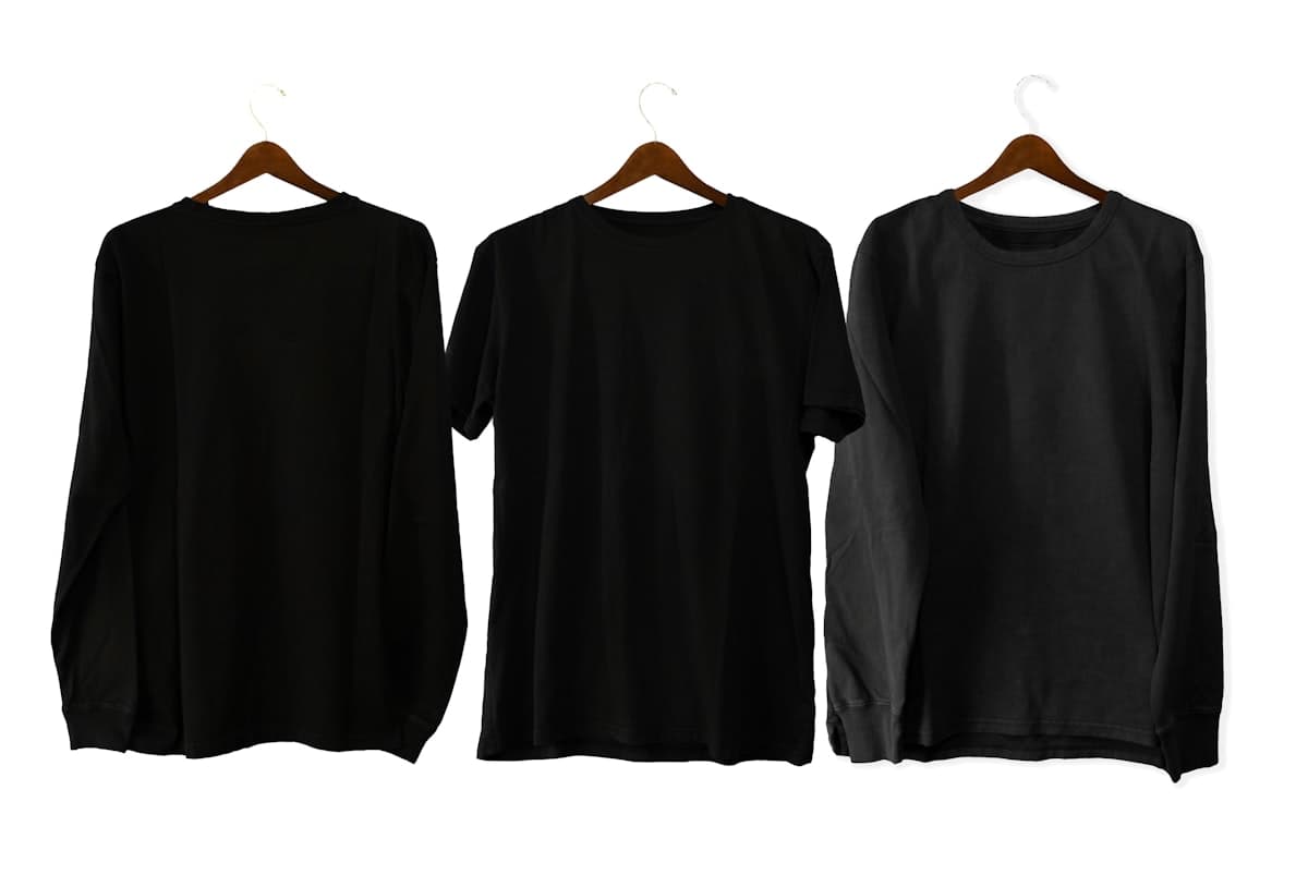Three black cotton M5 Outfit tees on wooden hangers