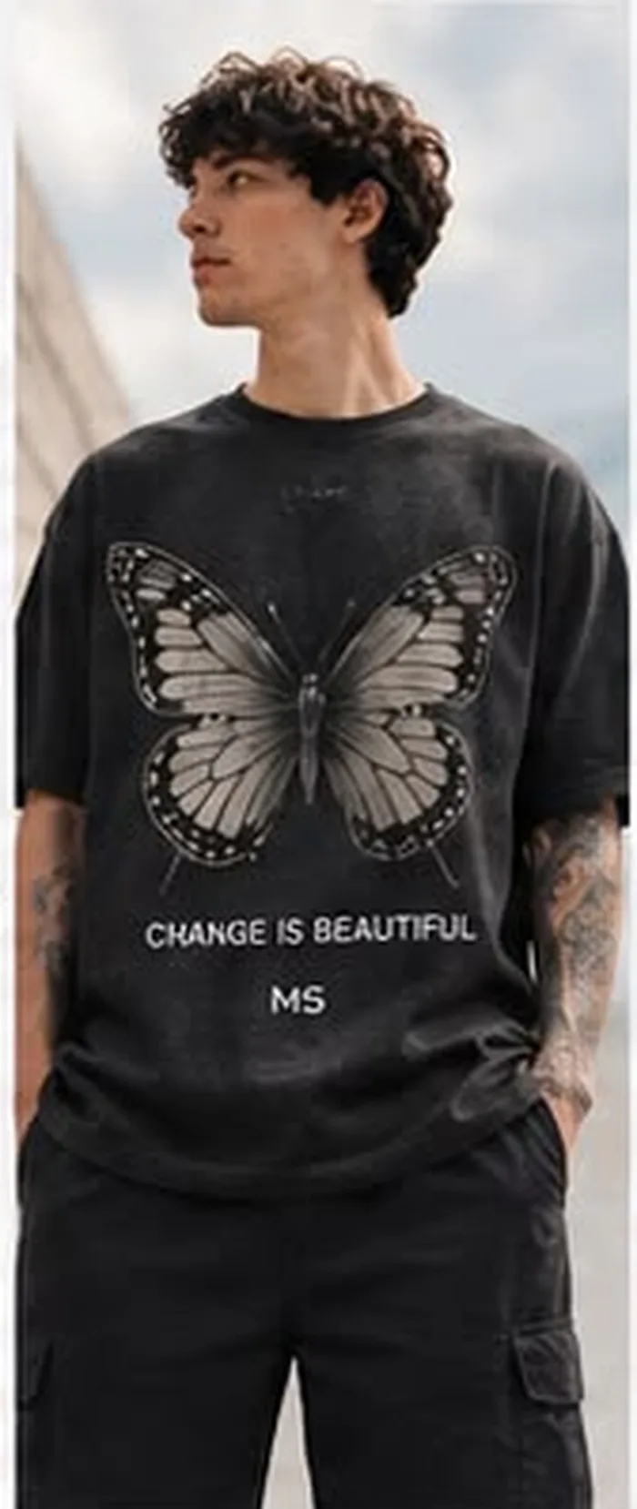 Model wearing a cream M5 Outfit T-shirt printed with a butterfly and Change Is Beautiful text